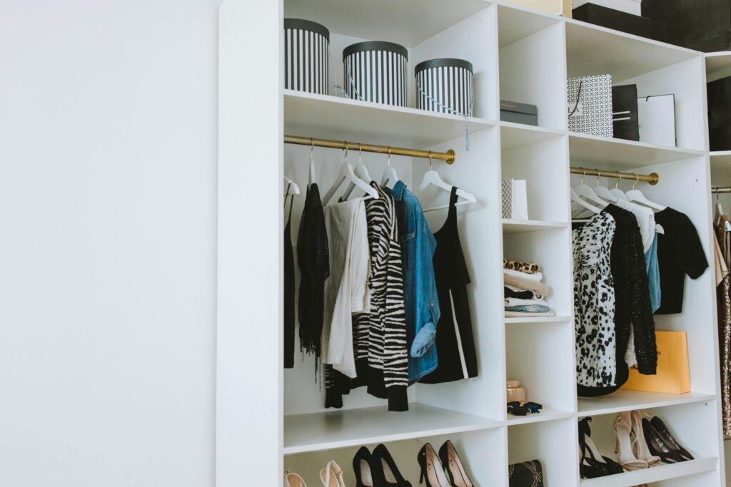 Neatly arranged wardrobe showcasing stylish clothes and shoes indoors.